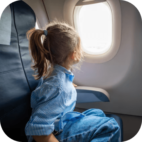 Kind blickt während des Flugs aus dem Flugzeugfenster